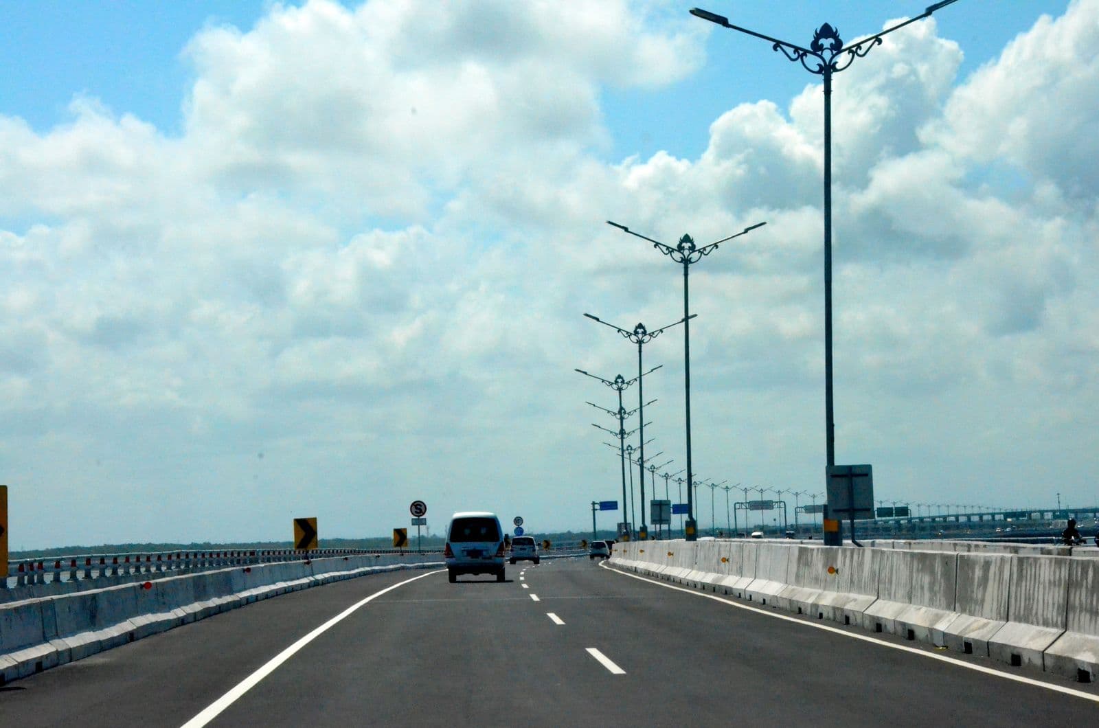 A private hire car driving on the Bali Mandara toll road near the airport